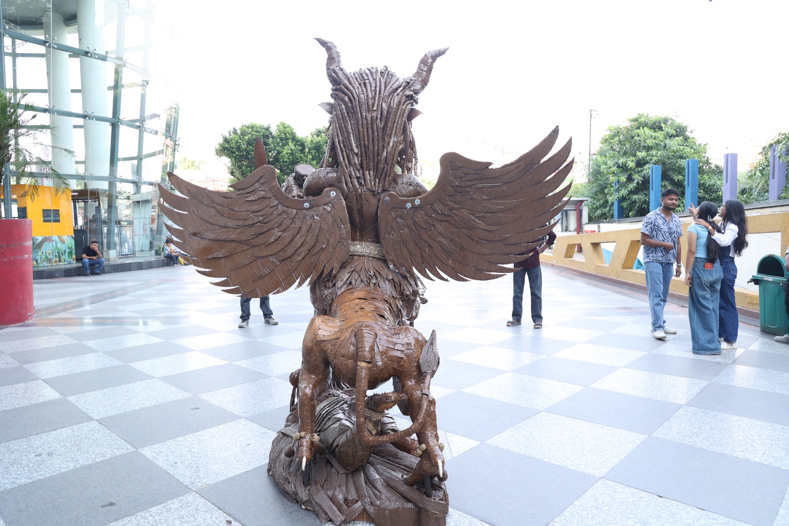 Rear view of the monumental sculpture Narasimha showcasing the 8-foot corrugated cardboard wingspan, plumage layering, and rear anatomy.